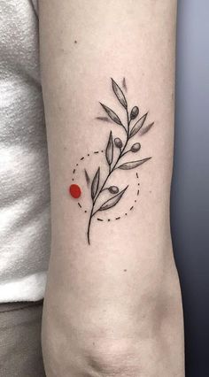 a tattoo on the arm of a woman with an olive branch and dots in it