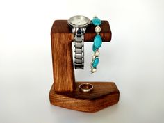 a wooden stand holding a watch and bracelet