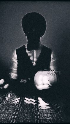 a black and white photo of a man holding a baby in his arms with the light shining on him