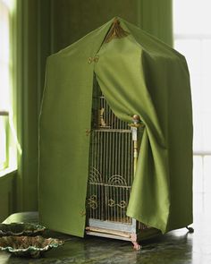 a bird cage with a green cover over it