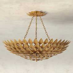 a chandelier hanging from a ceiling with leaves on the bottom and chains around it