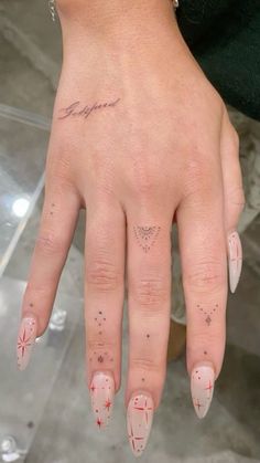 a woman's hand with pink and white nail polishes on her left thumb