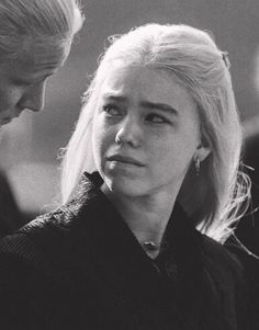 black and white photo of woman with blonde hair looking at man's earring