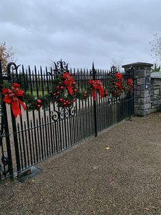 an iron fence decorated with wreaths and poinsettias