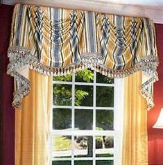 a living room filled with furniture and a large window covered in striped drapes next to a lamp