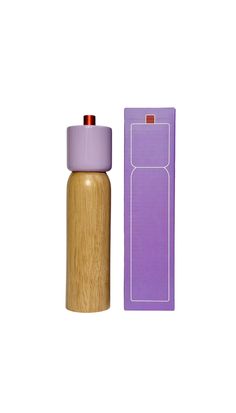 a purple bottle next to a cardboard box with a red cap on the top and bottom