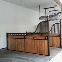 an empty room with some wooden doors and railings on the wall, in front of a white brick wall