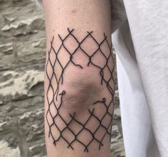 a person with a tattoo on their arm that has barbed wire in the shape of a face