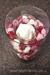 a glass filled with candy and marshmallows on top of a countertop