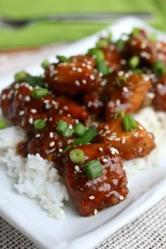 a white plate topped with rice and meat covered in sesame seeds