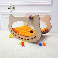 a cat bed made out of wood on the floor