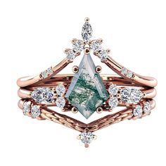 a green and white diamond ring set on top of two gold rings with diamonds around it