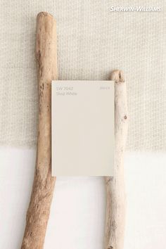 a piece of driftwood next to a white paint swatch