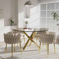 a glass table with chairs around it in a white and gold dining room set up