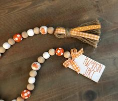 an orange and white beaded necklace on a wooden table with a tag that says pumpkin spice