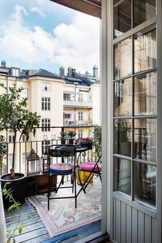 an open door leading to a balcony with tables and chairs