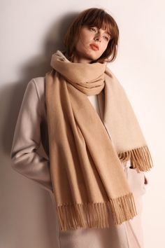 The Emes Shop scarf is detailed with a minimalist design. Features a fringe hem. knit material. and long length.MATERIAL:100% BrushedWool Blend Classic Beige Scarves For Fall, Classic Beige Scarf For Fall, Solid Color Fringe Scarf For Fall, Classic Beige Scarves, Winter Beige Fringe Shawl, Beige Fringed Winter Shawl, Beige Fringed Shawl For Winter, Elegant Fringed Scarves For Fall, Cream Wool Scarf For Fall