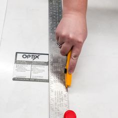 a person measuring the width of a piece of paper