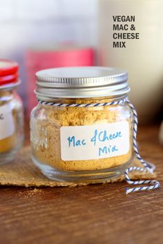 two jars filled with mac and cheese mix on top of a wooden table