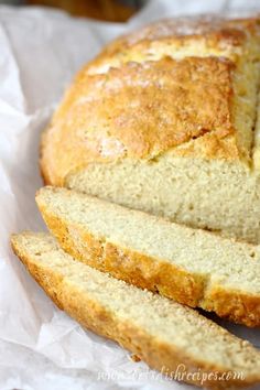 a loaf of bread cut into slices on top of wax paper