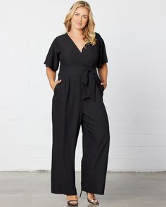 Jump from work to a wedding on the weekend in our Charisma Crepe Jumpsuit. Designed with a surplice neckline, short flutter sleeves and a detachable tie at the waistband. Pleated detail at the front and back of pant adds a tailored appearance. A zipper in the back makes getting in and out a breeze. The ideal jumpsuit for any occasion, you'll love this one and done style. Jumpsuit And Cardigan, One And Done, Chic Cardigan, Crepe Jumpsuit, Semi Annual Sale, Evening Gown Dresses, Vacation Looks, Surplice Neckline, Black Tie Wedding