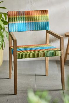 a colorful chair sitting next to a potted plant