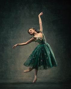 a ballerina in green dress posing for the camera