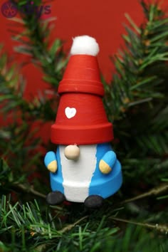 a christmas ornament with a red hat and blue car on it's side