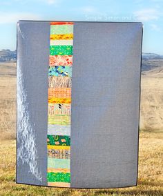 a quilted wall hanging in the middle of a field