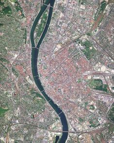 an aerial view of a river running through a city with lots of buildings and streets