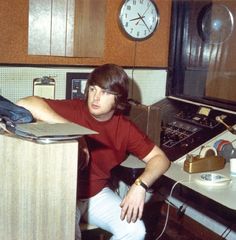 a man sitting at a desk in front of a clock