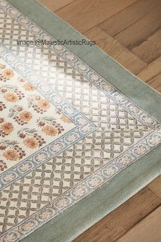 a close up of a rug on the ground with wood flooring in the background