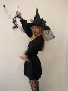 a woman dressed as a witch holding a wand