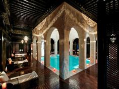 an indoor swimming pool surrounded by columns and lights