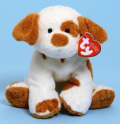 a brown and white stuffed dog with a tag on it's ear sitting against a blue background