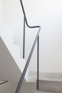 a white staircase with metal handrails leading up to the top