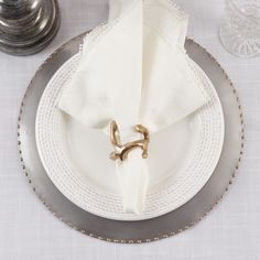 a white plate topped with a napkin and two gold rings