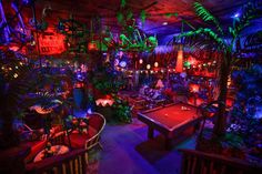 a room filled with lots of different types of plants and decorations on the walls, including pool tables