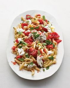 a white plate topped with pasta covered in fettuccine and tomato salad dressing