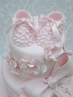 a pink cake decorated with pearls and bows