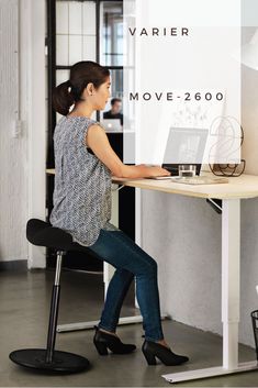 a woman sitting at a desk using a laptop computer