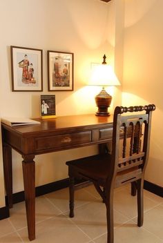 a desk with a lamp and pictures on the wall