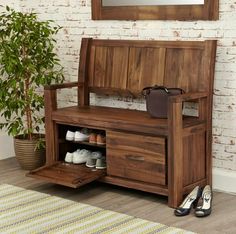 a wooden bench sitting next to a potted plant on top of a hard wood floor