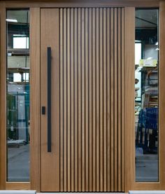 a close up of a wooden door on a building with glass windows and wood slats