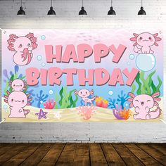 a happy birthday sign hanging from the side of a brick wall with sea animals on it