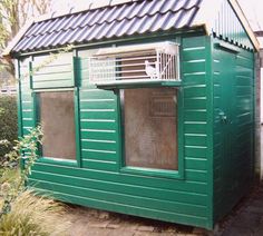 a small green building with a metal roof