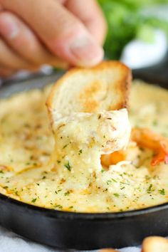 someone dipping some bread into a bowl of soup