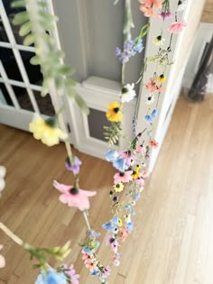 flowers are hanging from the ceiling in front of a door with a window behind them