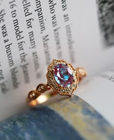 a pink ring sitting on top of an open book