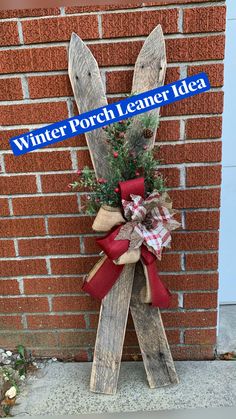 a wooden sign with a red bow on it that says winter porch leaner idea